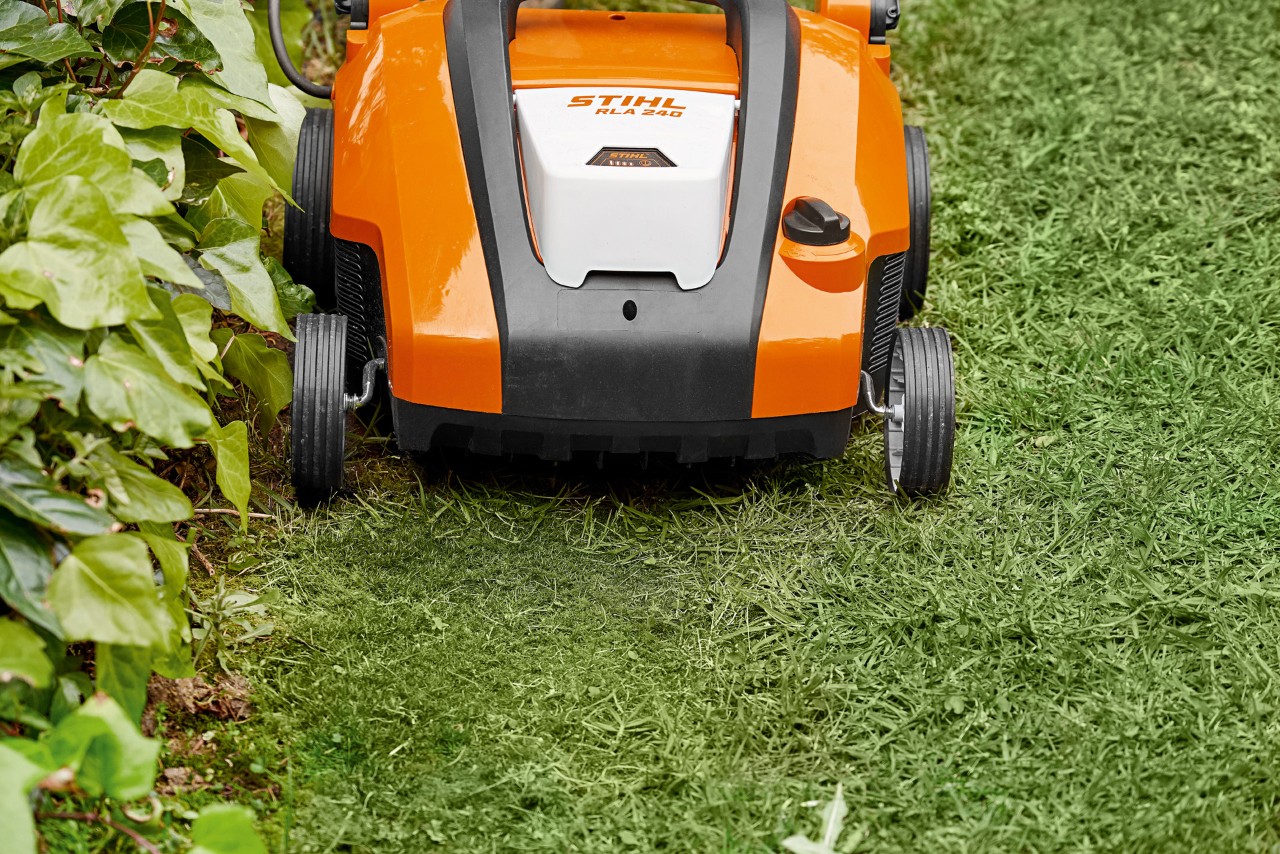 Zbliżenie na akumulatorowy aerator do trawnika STIHL RLA 240 przed piaskowaniem trawnika